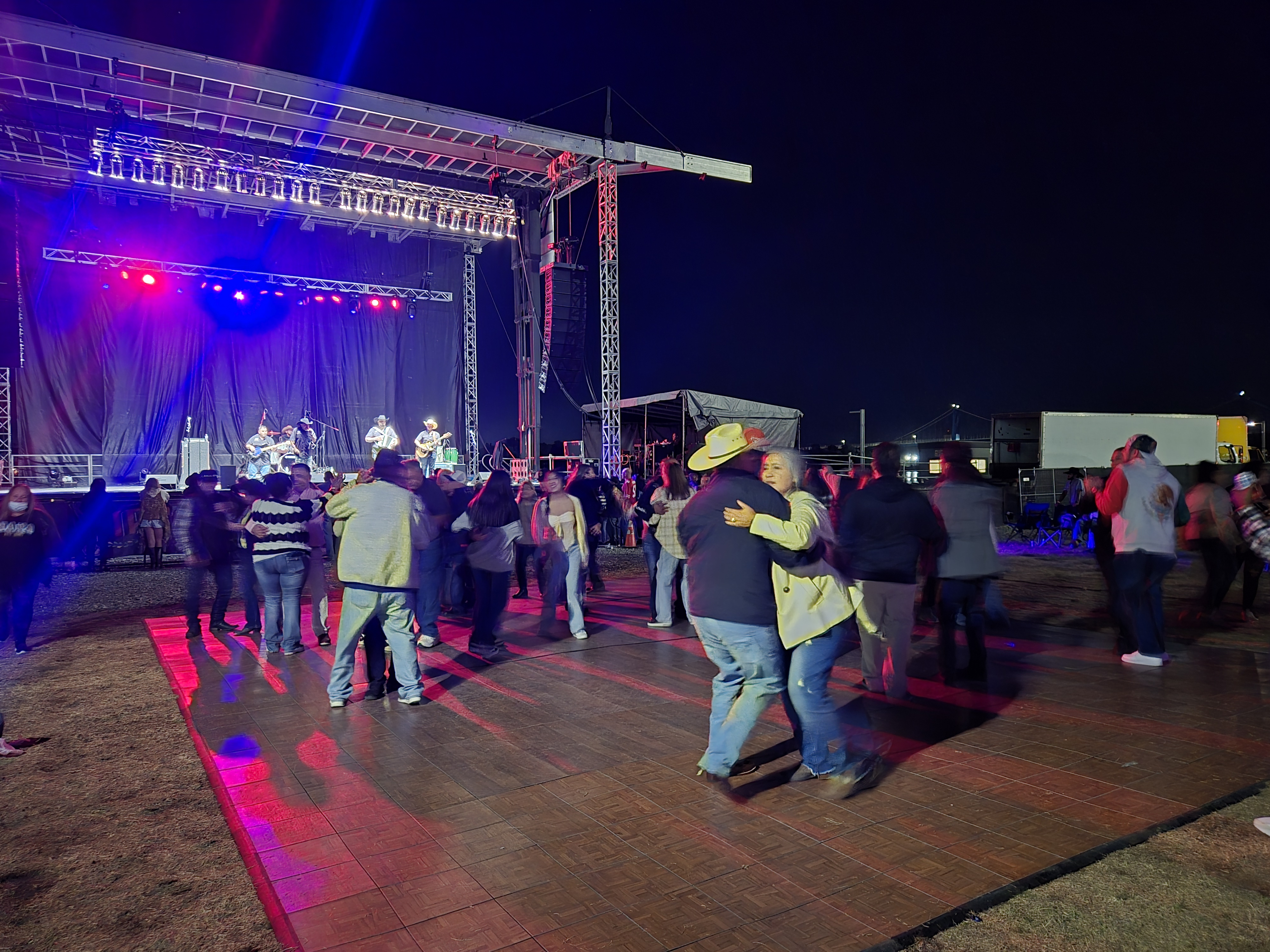 Outdoor concert event with dance floor and stage lighting at night